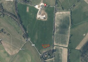 Property for sale Aerial view of fields intersected by roads, with a red marker on a building cluster near Limpsfield Road plot. A small area is outlined in red in a green field near Bush Farm Road. Freehold land Warlingham Surrey surrounds paths and woodlands. Presented by Palace Auctions