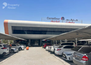 Property for sale A car park with several cars is in front of a modern Carrefour Market building, which has signs in both English and Arabic. Capri 2 and DAMAC Riverside Views are nearby, whilst the weather is sunny and clear. Presented by Palace Auctions