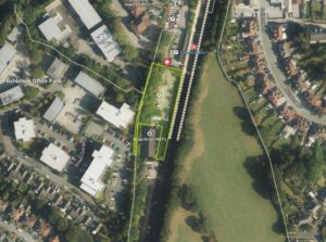 Property for sale Aerial view of Heald Green railway station and surrounding area, including railway tracks, buildings, office park, car park, roads, and green spaces—highlighting a potential Heald Green development land or mixed-use site SK8 within the yellow-outlined station area. Presented by Palace Auctions