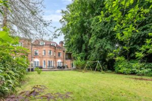 Property for sale Grand 11-bed mansion featuring white-trimmed windows and arched doors, set on Winnington Road. Enjoy views from a spacious green lawn with a metal swing set, surrounded by lush greenery—ideal for families or redevelopment potential. Presented by Palace Auctions