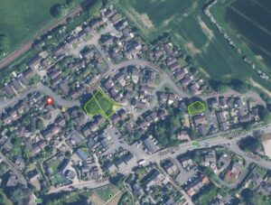 Property for sale Aerial view of a Helsby suburban neighbourhood with houses, roads, amenity land, and green spaces; some areas are outlined in yellow, and a red pin marks a location on Plovers Lane. Surrounding fields and trees are visible. Presented by Palace Auctions